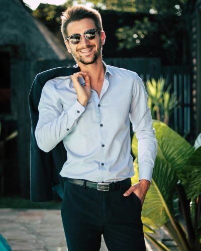 Confident young man in a stylish suit outdoors, exuding charm and elegance.